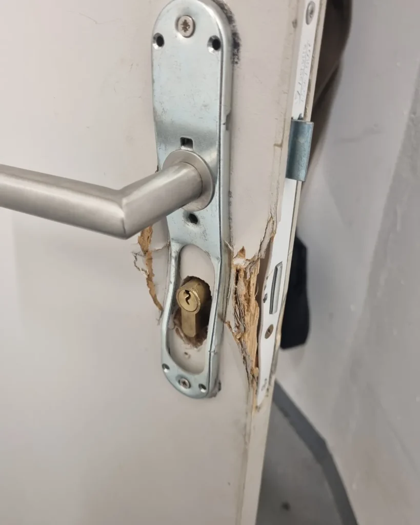 Porte d'entrée endommagée après une effraction à Nice, bois éclaté autour de la serrure — mise en sécurité Arti.AI